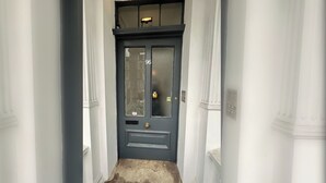 A narrow hallway with a dark blue door marked with the number 96, flanked by white columns. - Stylish 2BD Victorian Home near Holland Park (London)