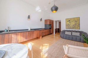Uma cozinha moderna com armários de madeira, bancada de mármore e forno embutido.