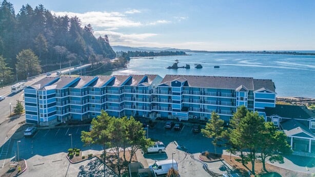 Ein mehrstöckiges Hotel mit blauer Fassade in der Nähe eines Gewässers, auf dem Boote fahren.