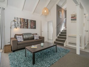Relax in this stylish living room with a sofa, coffee table, and abstract art.