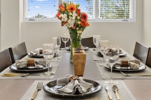 Enjoy a beautifully set table, complete with fine china, crystal glasses, and a lovely floral centerpiece.