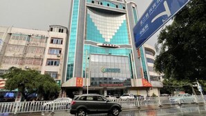 A modern building with a prominent glass facade and a sign indicating a medical facility. - City Comfort Inn Laibin Liulai (Laibin)