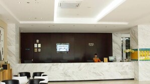 A hotel reception area with a marble counter, a receptionist, and modern seating. - City Comfort Inn Laibin Liulai (Laibin)