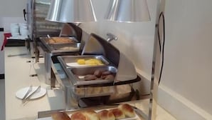 A buffet setup with various food items, including bread rolls, pastries, and hot dogs. - City Comfort Inn Laibin Liulai (Laibin)