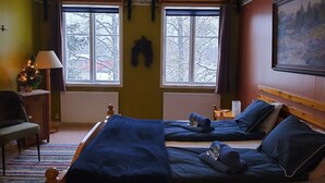 A bedroom with two beds, a window with a view of trees, a radiator, and a lamp. - Hammarstrand Budget Hotell Vandrarhem - Hostel (Hammarstrand)