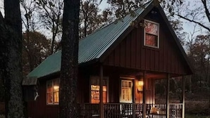 A wooden cabin with a porch and a metal roof, surrounded by trees. - Modern, Private Cabin 20 Minutes From Penn State, Breakfast Items Included (Philipsburg)