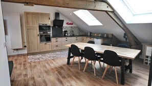 Una cocina moderna con armarios de madera, una mesa de comedor con sillas y un tragaluz.