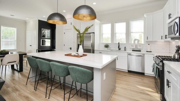 A modern kitchen with a central island, bar stools, pendant lighting, and stainless steel appliances. - Paradise Palace Best Rooftop in HTX w/ Hot Tub (Houston)