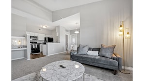 A modern living room with a grey sofa, a marble coffee table, and a floor lamp.