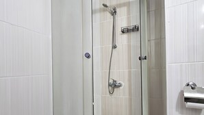 Un baño moderno con ducha de vidrio, inodoro y lavamanos.