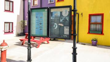 A colorful building with a plaque and a bench in front.