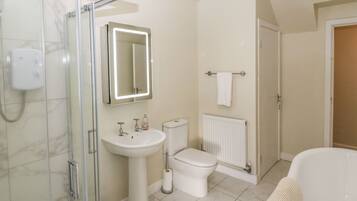 A bathroom with a glass shower enclosure, a pedestal sink, a toilet, and a bathtub.