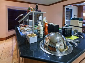 A buffet setup with various food items and condiments. - Nw Near Six (San Antonio)
