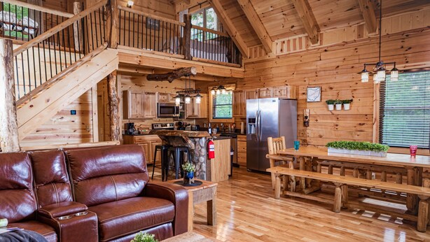 A spacious wooden cabin with a kitchen, dining area, and a leather sofa. - Hidden Creek Lodge by The Inn & Spa at Cedar Falls (Creola)