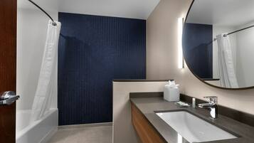 A modern bathroom with a bathtub, a sink, and a mirror.