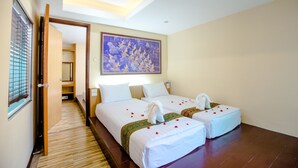 A hotel room with two beds, a painting on the wall, and a wooden floor. - The Landmark Patong (Patong)