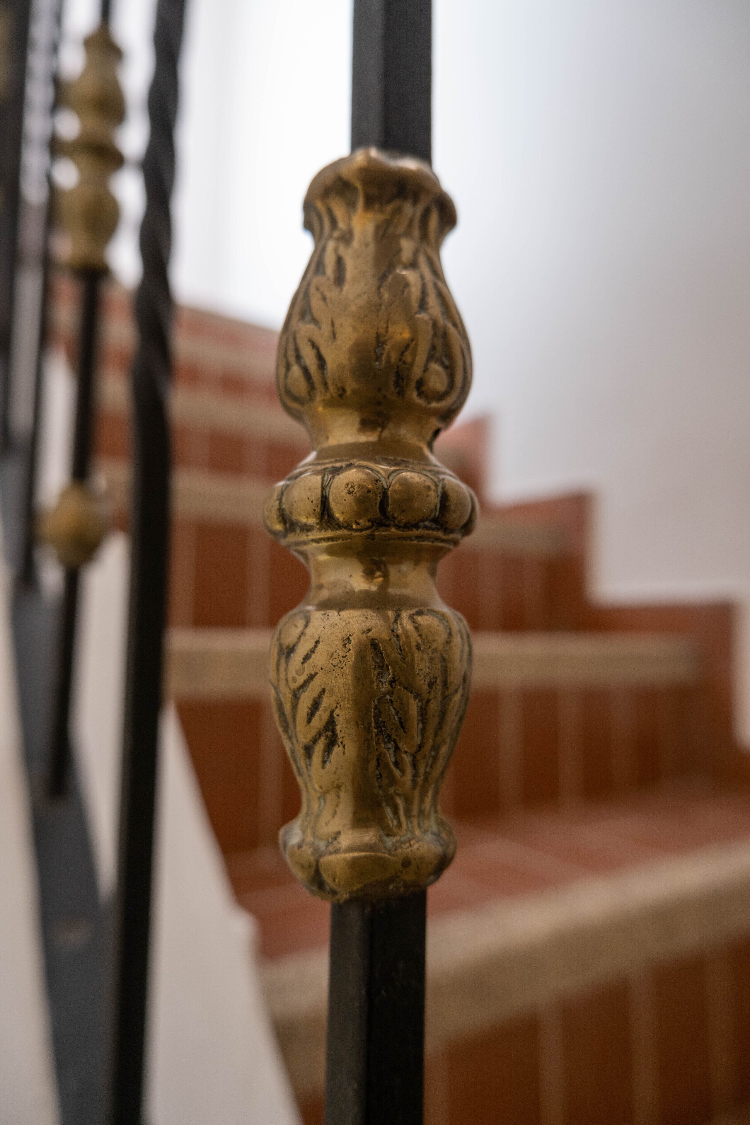 Een close-up van een decoratieve metalen balustrade met ingewikkelde versieringen.