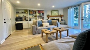 A living room with a sofa, two coffee tables, a fireplace, and a bookshelf. - Guest Suite near UNC! (Chapel Hill)