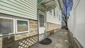 A house with a stone foundation, a front door, and a small porch area.