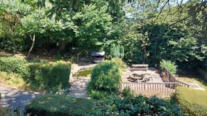 Ein Garten mit Holzterrasse, Picknicktisch und einem kleinen Teich.