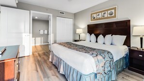 Ein Hotelzimmer mit Bett, Nachttischen, einem Schreibtisch und einem Deckenventilator.