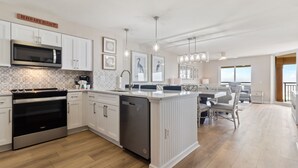 Een moderne keuken met witte kasten, roestvrijstalen apparatuur en een centraal eiland.