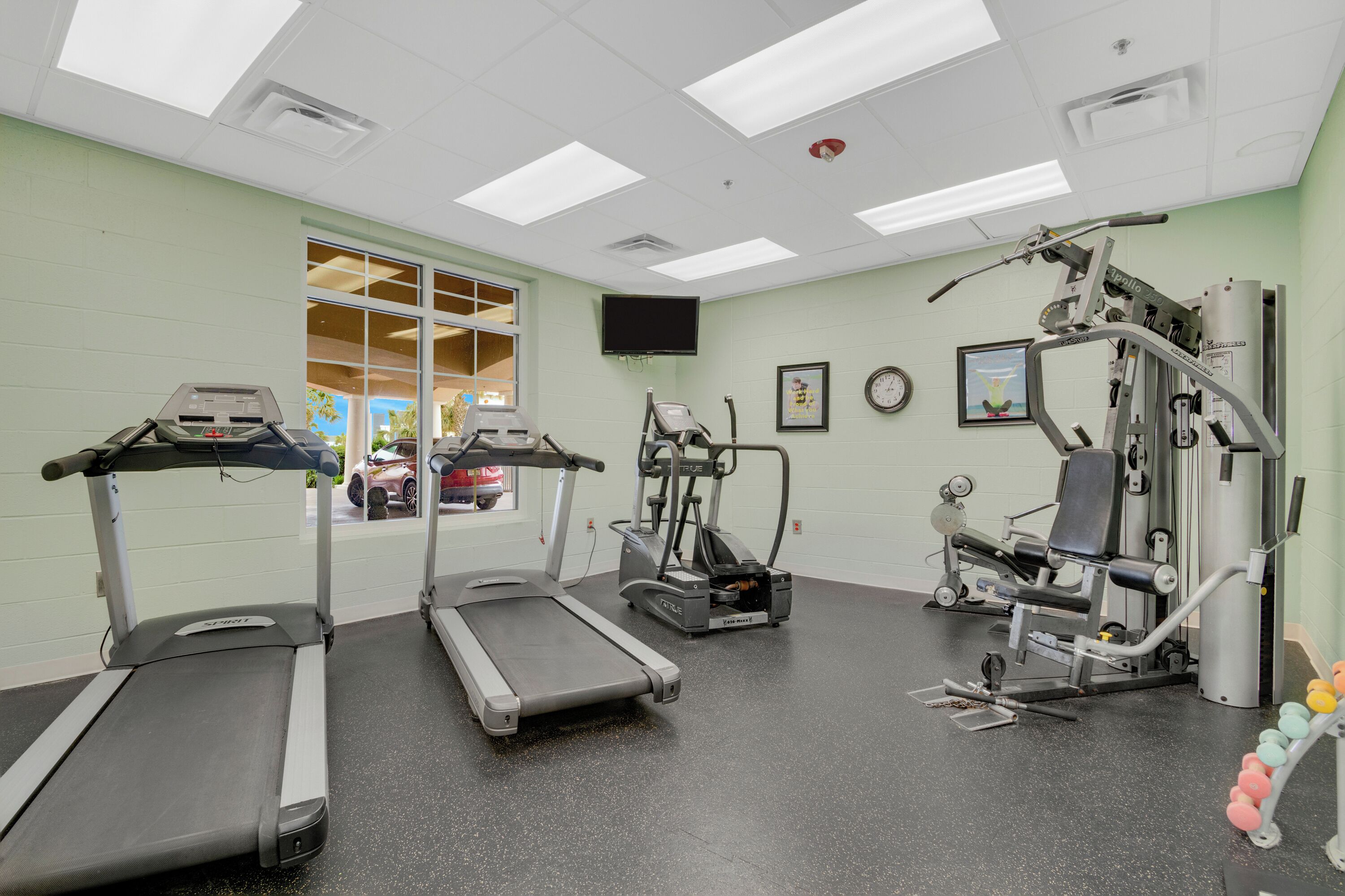 A gym with treadmills, an elliptical, and weight machines.
