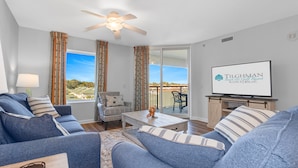 A living room with a sofa set, a coffee table, a TV, and a ceiling fan. - 3BR- 5th floor- Lake & Golf View condo|Short walk to beach| Resort Access| (North Myrtle Beach)