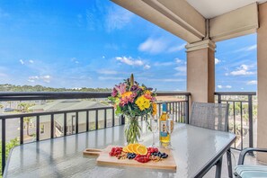 Enjoy a meal or social gathering on the balcony with a view, surrounded by fresh flowers and a beautifully set table.