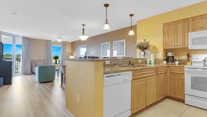 A modern kitchen with wooden cabinets, a built-in dishwasher, and a large island. - 3BR- 6th floor- Lake & Golf View condo|Short walk to beach| Resort Access| (North Myrtle Beach)