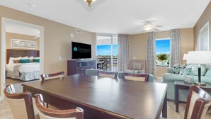 A hotel room with a dining area, a TV, a balcony with a view, and a bed with a headboard. - 3BR- 6th floor- Lake & Golf View condo|Short walk to beach| Resort Access| (North Myrtle Beach)