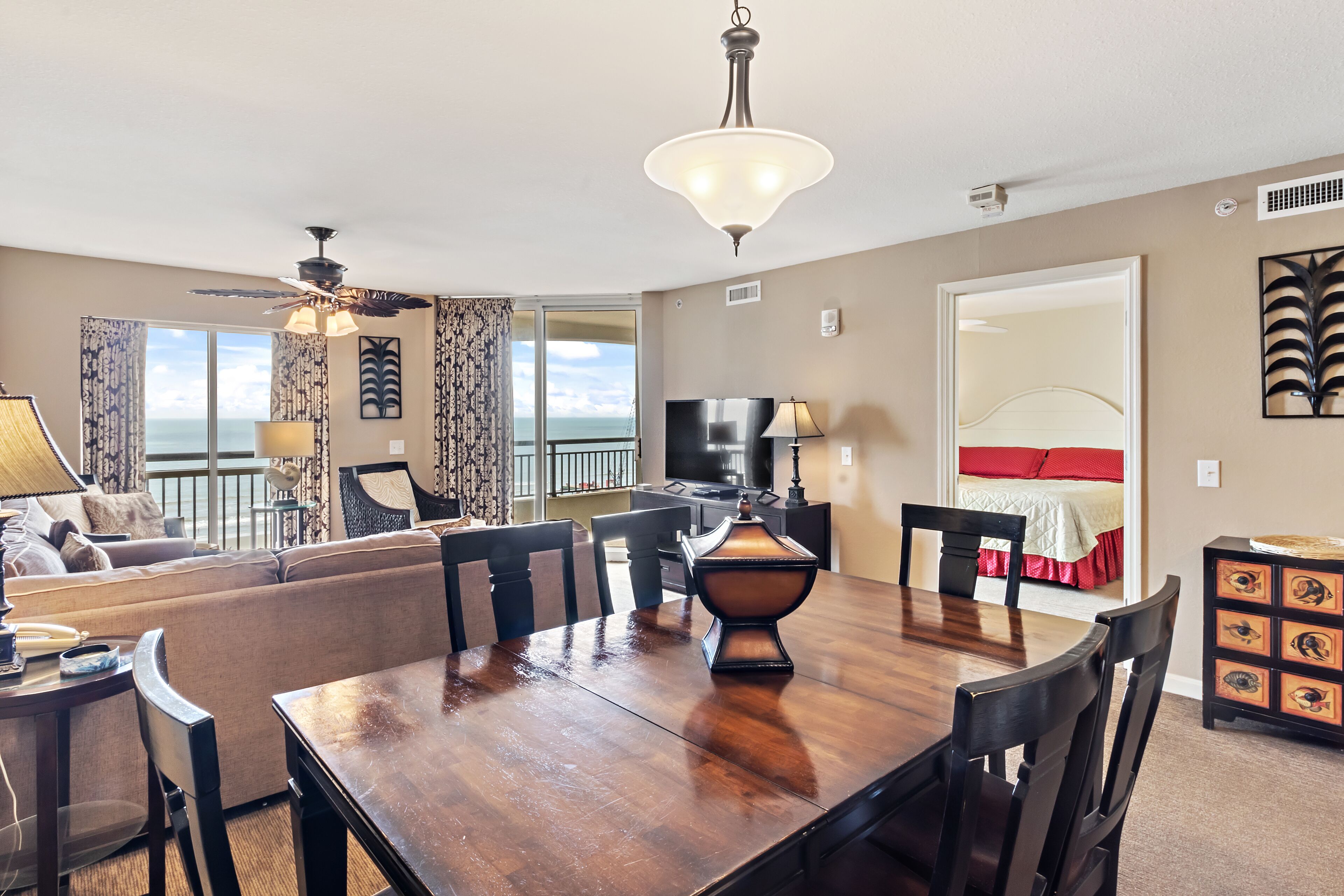 A spacious living area with a dining table, chairs, a sofa, and a TV.