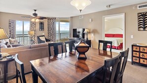 Un salón amplio con una mesa de comedor, sillas, un sofá y una televisión.