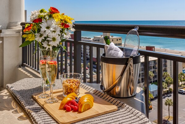 Enjoy a refreshing breakfast on the balcony with a stunning ocean view, complete with fresh fruit and a refreshing drink.
