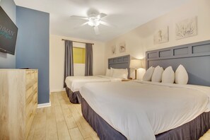 A hotel room with two beds, a ceiling fan, a TV, and artwork on the walls. - 3BR- 5th floor Oceanview condo|Short walk to beach (North Myrtle Beach)