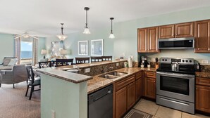 A modern kitchen with granite countertops, stainless steel appliances, and wooden cabinets.