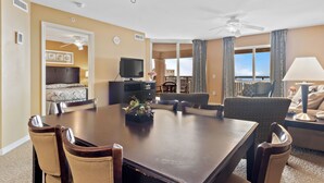Une chambre d’hôtel dotée d’une grande table à manger, de sièges confortables, d’une télévision et d’un balcon avec vue.