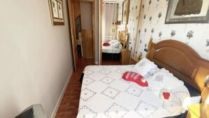 Ein Schlafzimmer mit einem Bett, einem hölzernen Kopfteil, einem Nachttisch und einem Kleiderschrank.