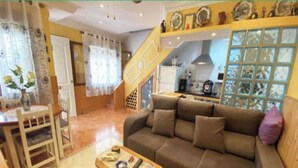 Ein Wohnzimmer mit einer Couch, einem Couchtisch und einer Treppe, die zu einer oberen Ebene führt.