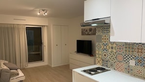 Een moderne keuken met een ingebouwde kookplaat, een televisie en een decoratieve spatwand.
