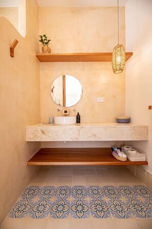 A bathroom with a marble sink, a round mirror, a hanging light fixture, and patterned floor tiles. - Luxury mediterranean Villa, perfect location (Mérida)