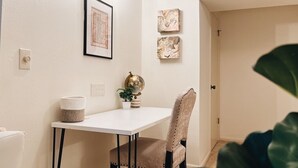 Un pequeño comedor con una mesa blanca y una silla, un globo terráqueo y cuadros en la pared.