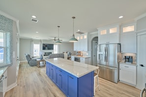 A modern kitchen with a large island, white cabinetry, and stainless steel appliances. - Beachfront Beauty with Bay Views and Boat Ramp Access (Freeport)
