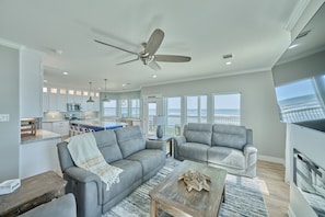 A spacious living area with a gray sofa, a wooden coffee table, and a fireplace. - Beachfront Beauty with Bay Views and Boat Ramp Access (Freeport)