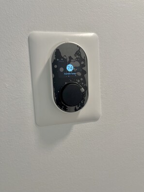 A thermostat with a digital display indicating a temperature of 74 degrees. - New Air (Pompano Beach)