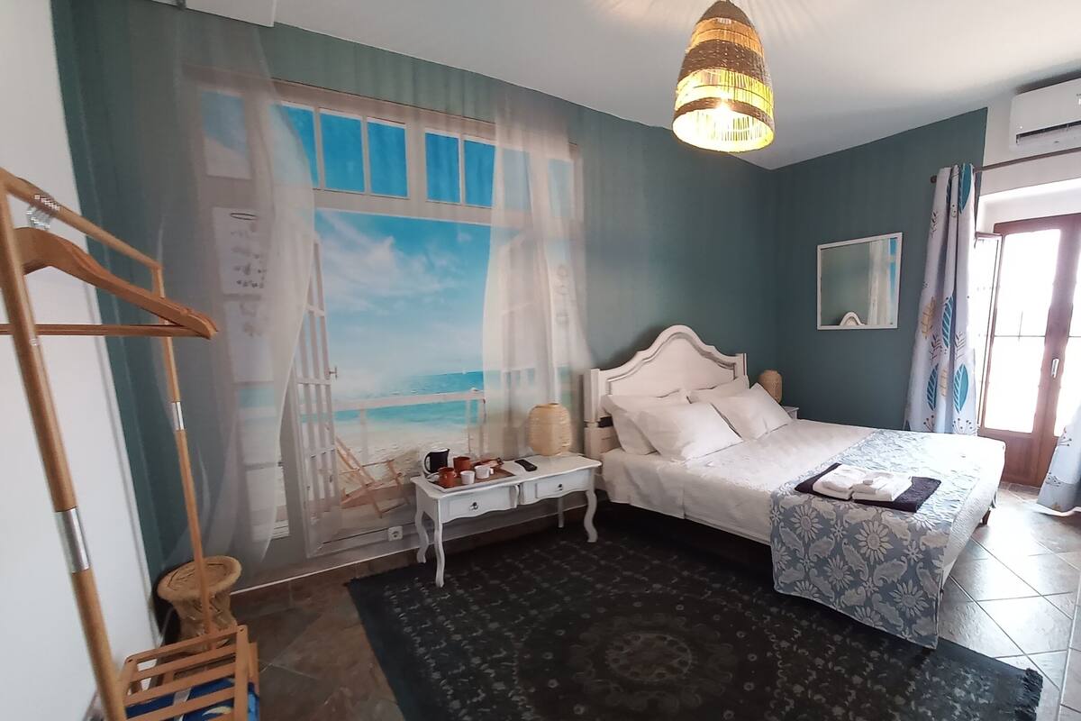 Un dormitorio con cama, mesita de noche y lámpara colgante.