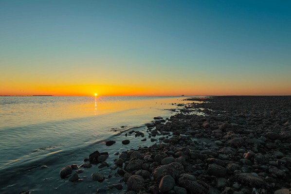 A rocky beach at sunset with calm water and a clear sky. - DUNE Fairfield Beach (Fairfield)