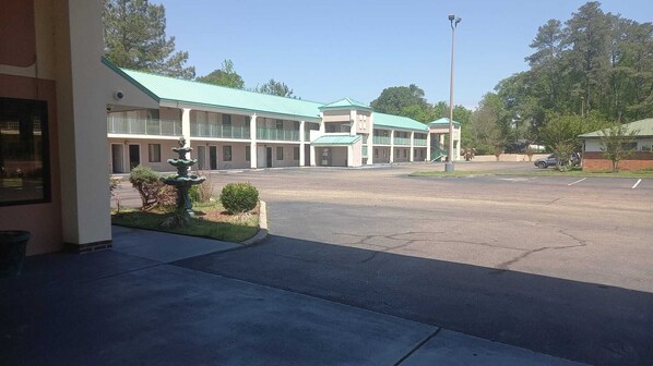 A motel with a central courtyard, multiple balconies, and a fountain.