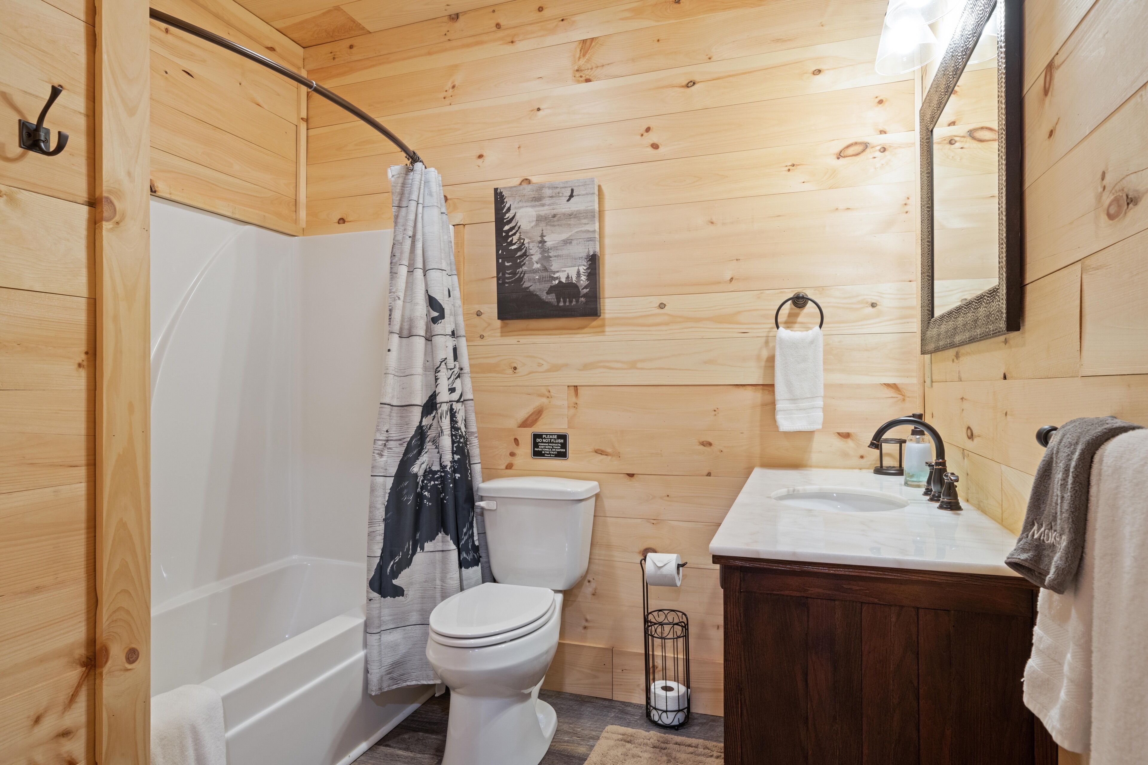 Bagno di una casetta in legno con vasca, WC e lavandino.