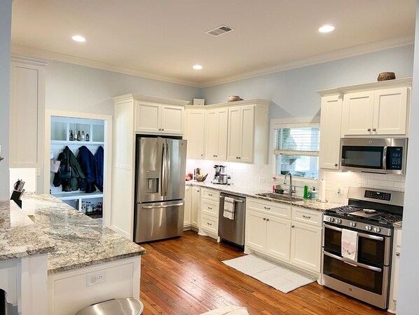 Enjoy cooking in this well-lit kitchen with a refrigerator, oven, and microwave.